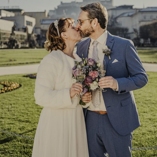 Marian und Tanja bei ihrer Winterhochzeit im Schloss Mirabell Salzburg, emotionale Trauung im Marmorsaal und romantische Momente im verschneiten Mirabellgarten.
