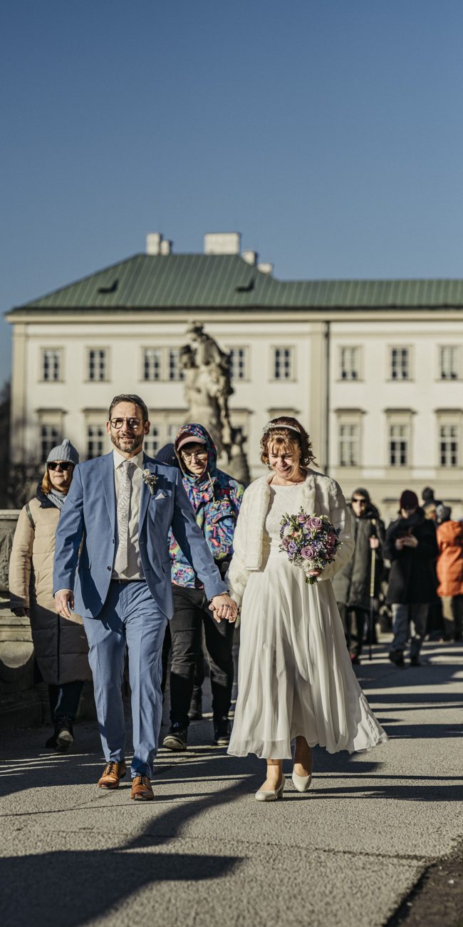 Marian und Tanja bei ihrer Winterhochzeit im Schloss Mirabell Salzburg, emotionale Trauung im Marmorsaal und romantische Momente im verschneiten Mirabellgarten.